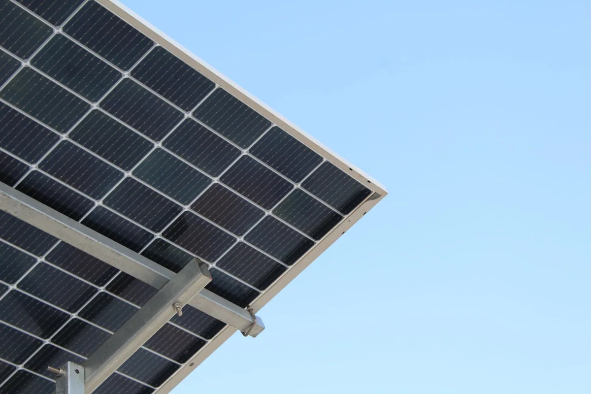 Panel solar bifacial visto desde abajo sobre una estructura elevada de acero, con las células visibles por su cara trasera
