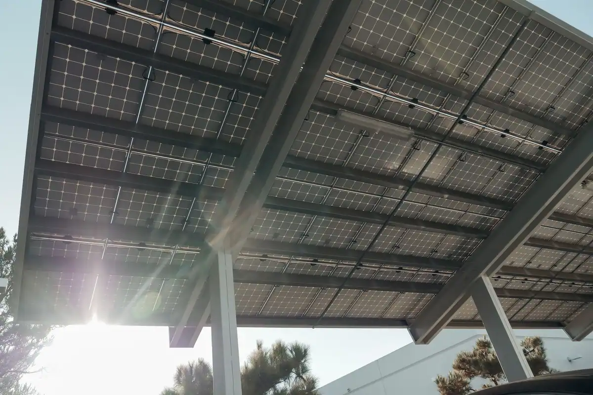 Estructura de una pérgola fotovoltaica vista desde abajo, con las vigas y los soportes de los paneles
