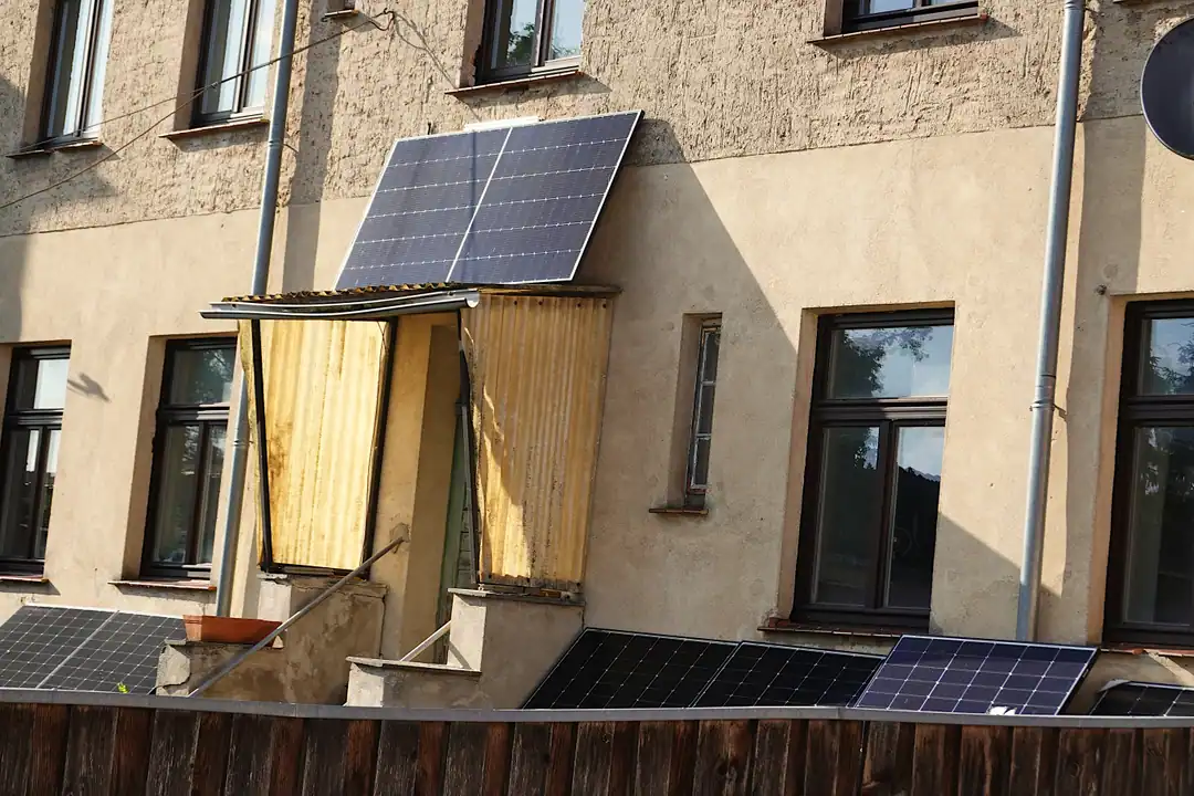 Placas solares de balcón en la fachada y junto a la valla de un edificio de pisos