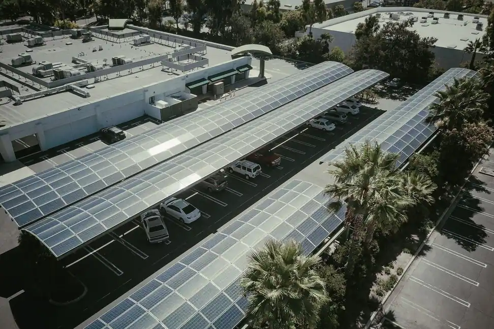 Marquesinas con placas solares que dan sombra al aparcamiento de un edificio de empresas, vistas desde el aire