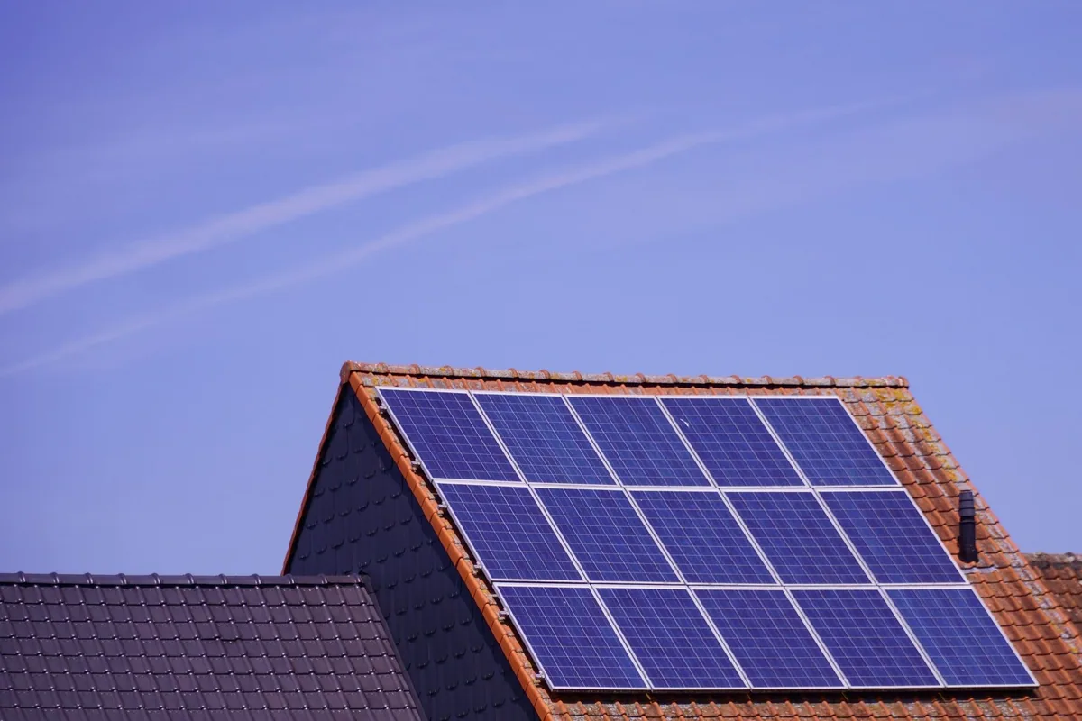 Tejado de teja de una vivienda con quince paneles solares colocados en tres filas