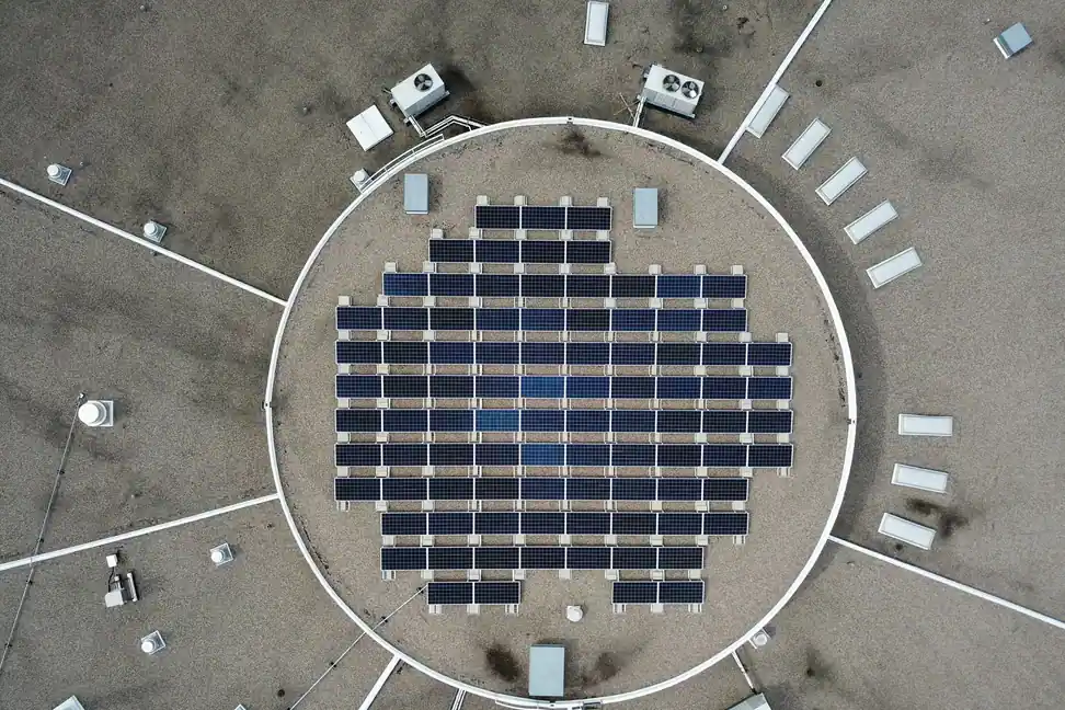 Placas solares y unidades exteriores de climatización en la misma azotea plana, vistas desde lo alto